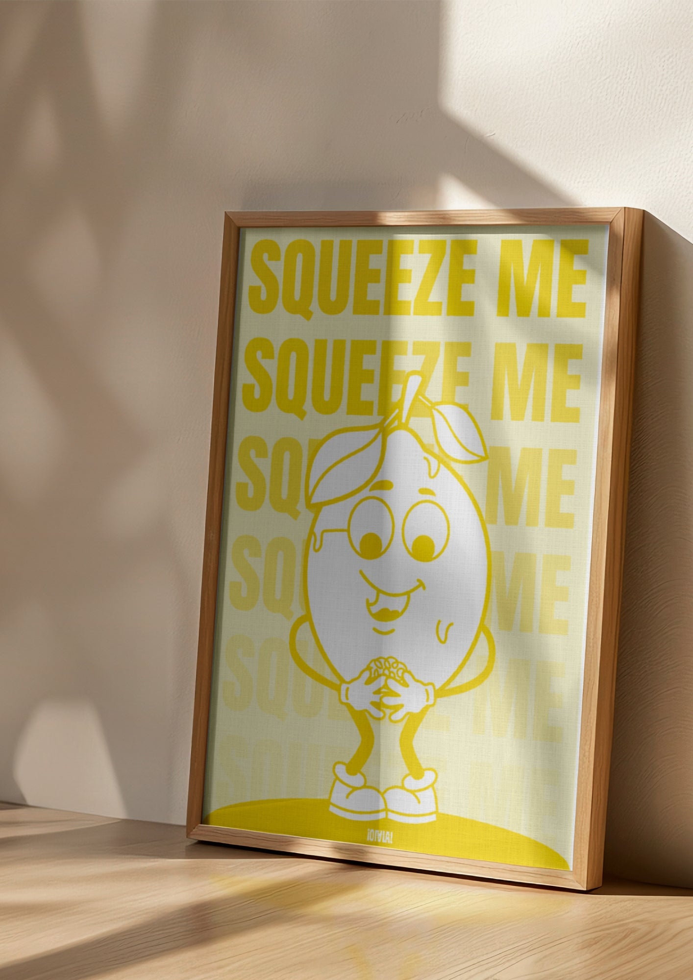 Affiche avec fond jaune. Au centre, une illustration d'un citron avec une expression embarassée En fond. la phrase "squeeze me" est déclinée en étant de plus en plus transparente vers le bas. L'affiche est dans un cadre posé au sol.