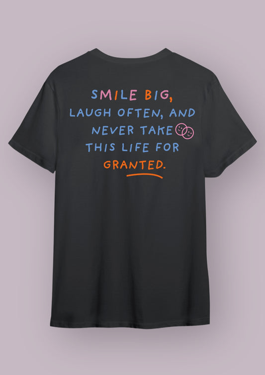 T-shirt noir avec la phrase "smile big, laugh often, and never take this life for granted". Cette phrase est écrite en bleue, rose et orange.